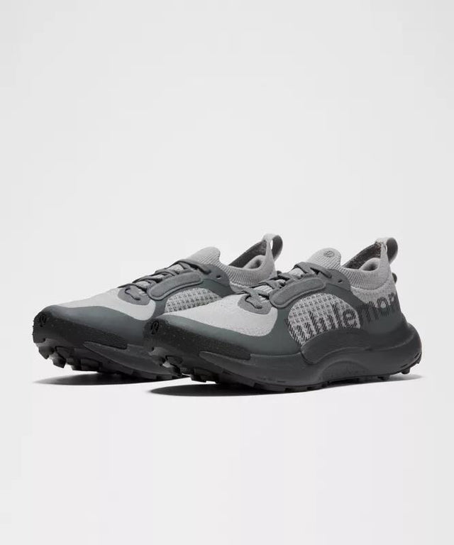 A trail running shoe photographed on a clean background